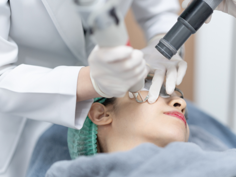 Aesthetician performing a laser treatment on a patient's face