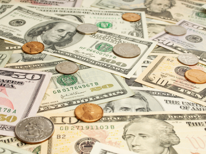 Various denominations of U.S. dollar bills and coins scattered