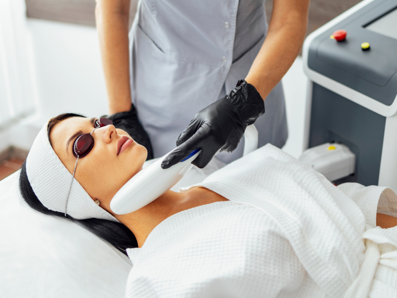 Woman receiving laser neck tightening treatment while wearing eye protection