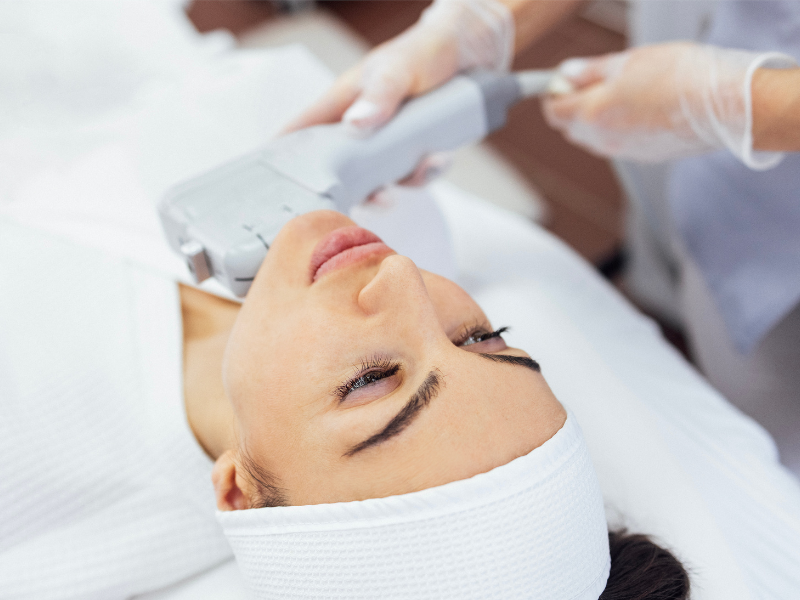 Woman receiving a non-surgical facelift procedure with professional device