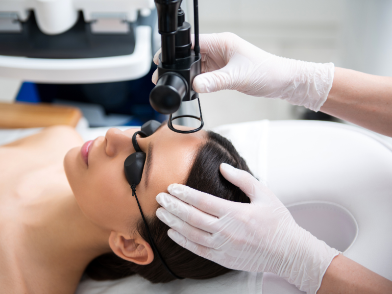 A woman undergoing a laser skin procedure with protective goggles