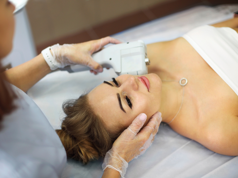 Medical professional performing skin tightening treatment on woman's face