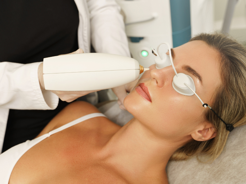Aesthetician performing laser treatment for dark circles under eyes