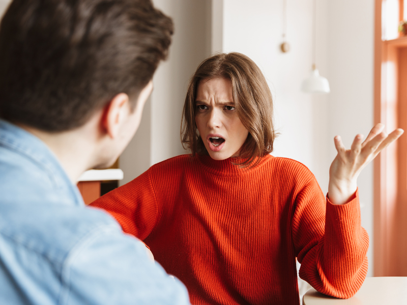A woman in red sweater arguing with her partner angrily