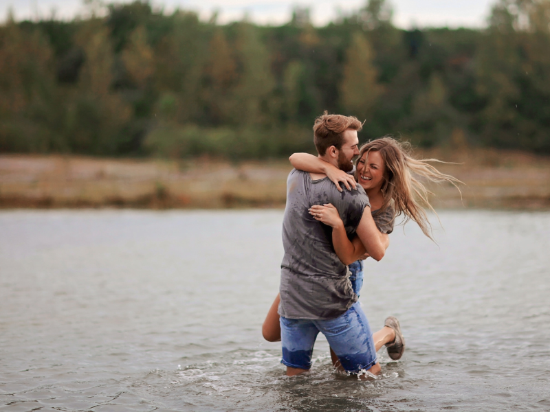 A couple playing and laughing together in the shallow water