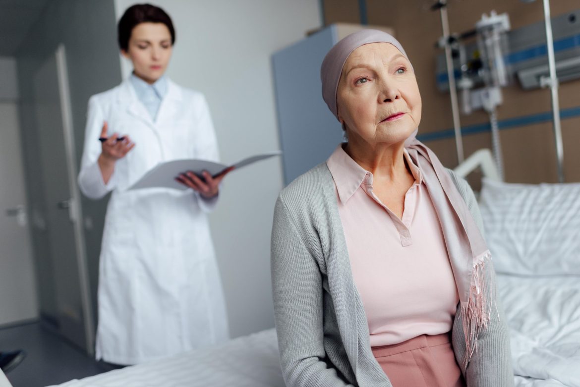 elderly woman with cancer sitting on her bed