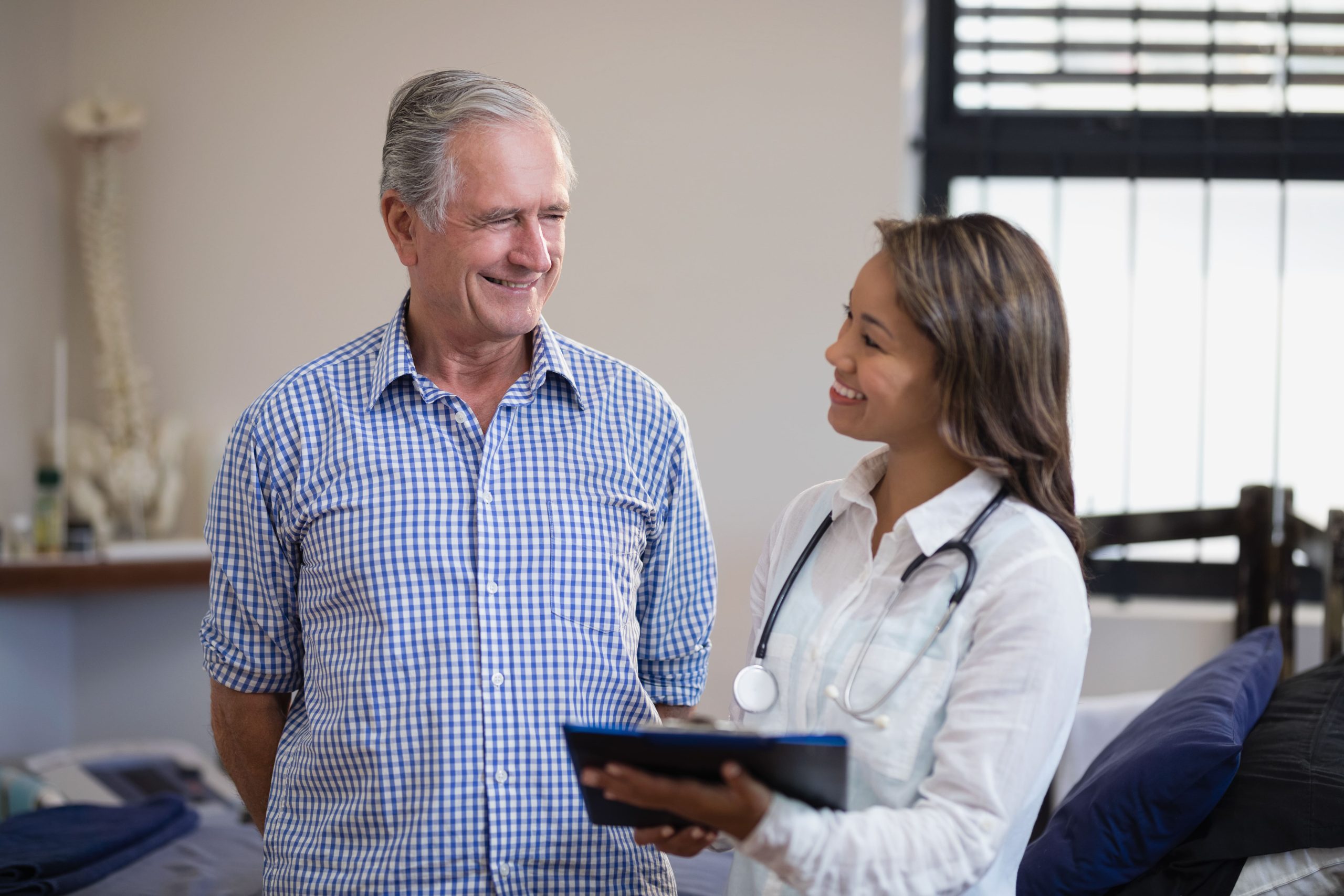 young female doctor speaking with an elderly male patient