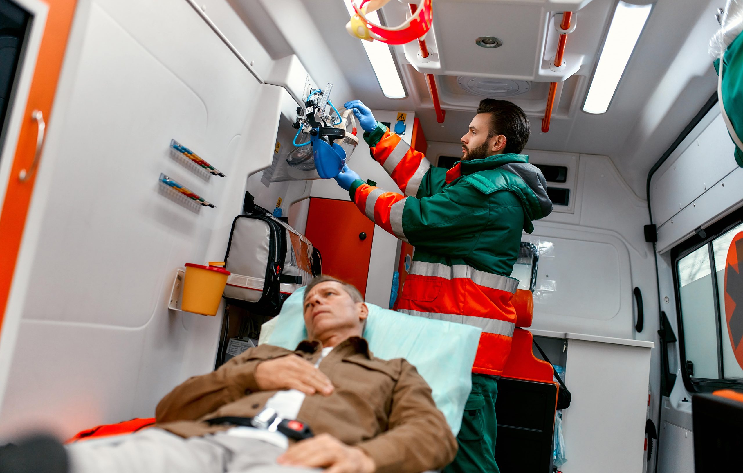 elderly man inside an ambulance with hand on his stomach