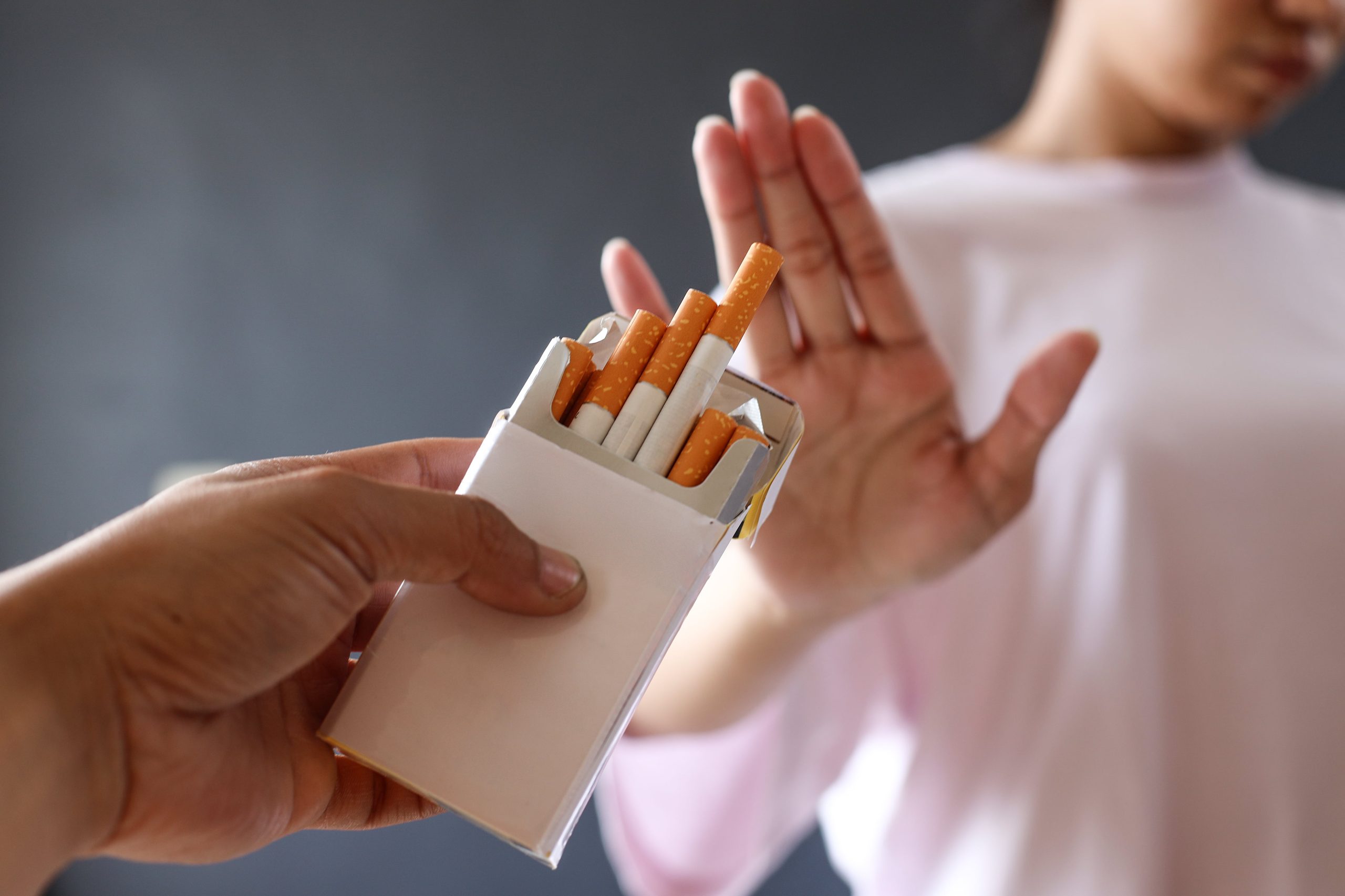 woman refusing a box of cigarettes