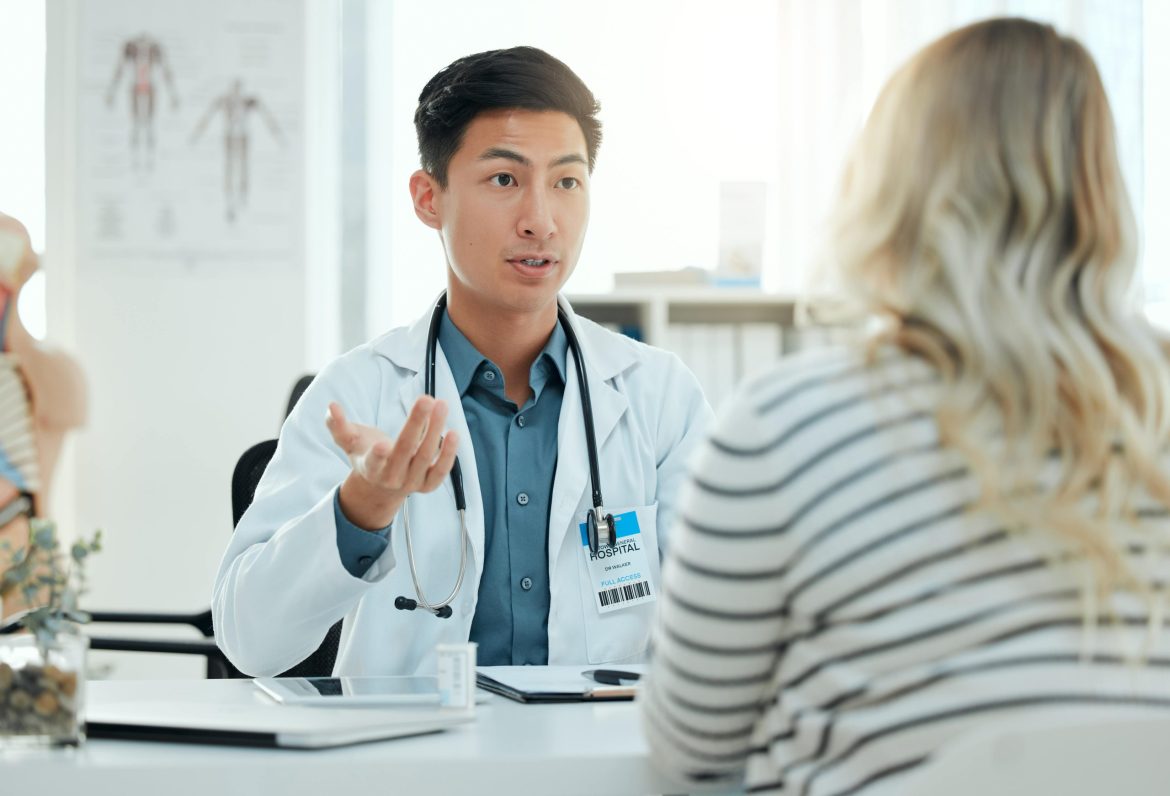 young male doctor speaking with a female patient