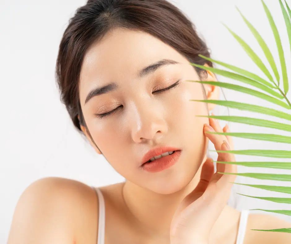 Woman with flawless skin touching her face with a serene expression