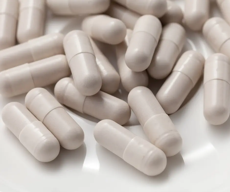 Close-up of white capsule supplements on a plate
