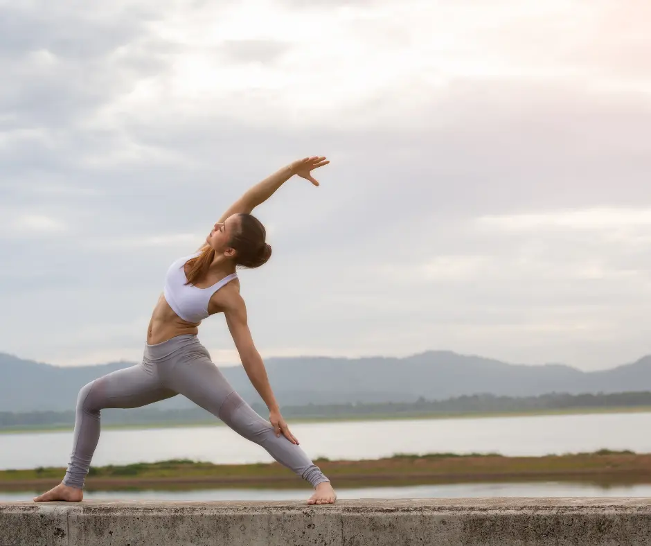 Woman stretching in yoga pose with scenic background view