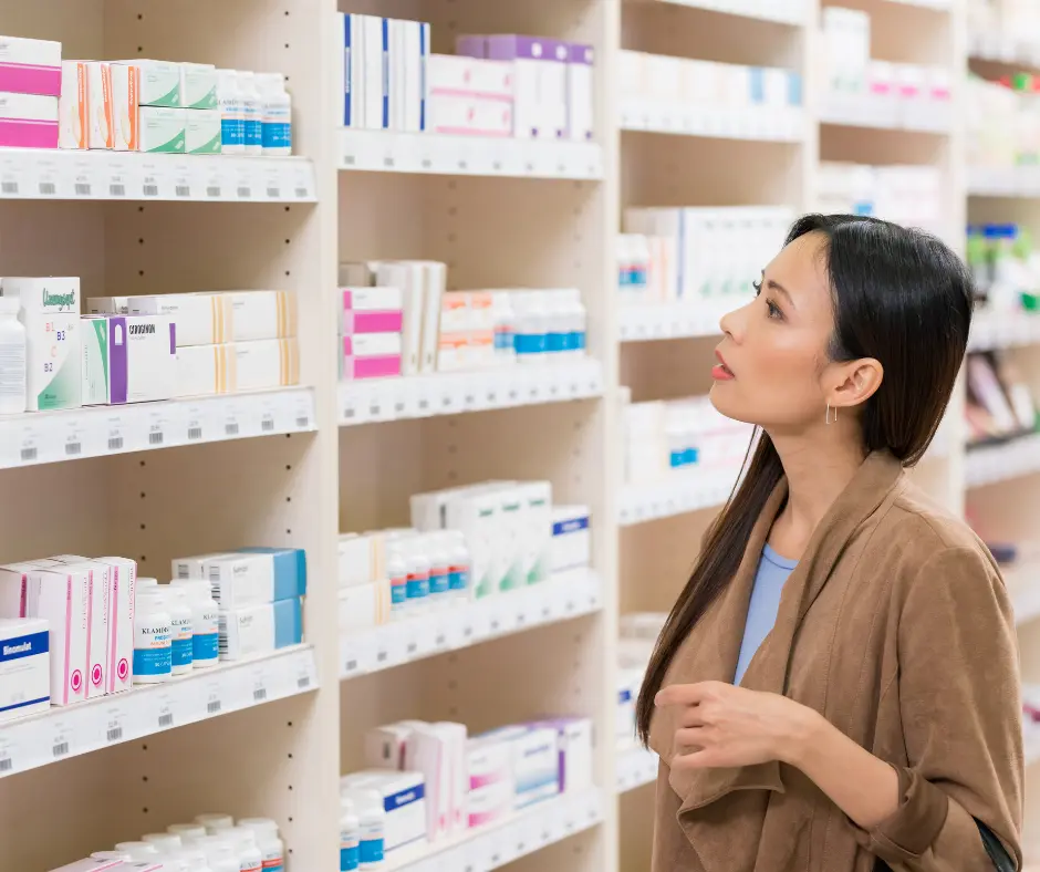 A woman browsing medication and skincare products at a pharmacy
