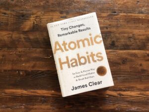 “Atomic Habits book on a wooden table