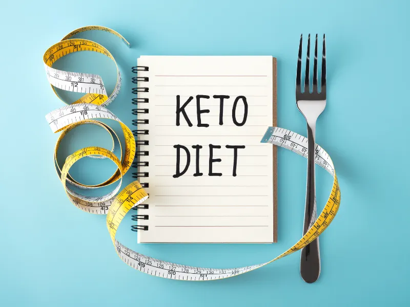 Notebook with 'Keto Diet' written, surrounded by measuring tape