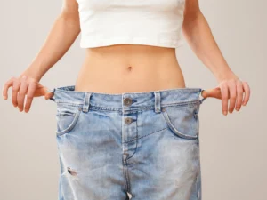 Person wearing oversized jeans after significant weight loss success