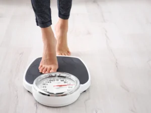 Person stepping onto a scale to check weight progress