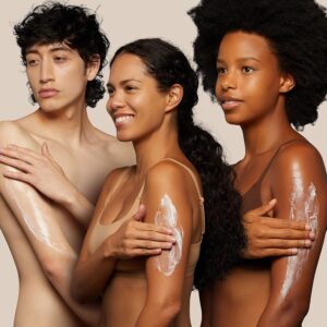 2 women and a men showing to spread the lotio on their arm