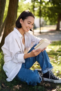 a beautiful woman reading a book at the park
