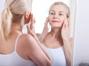 Woman compares her face in the mirror while considering bovine collagen vs marine collagen differences